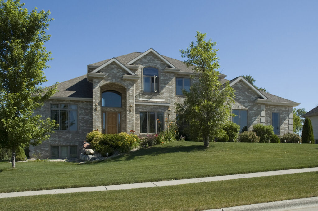 Luxury two-story stone and brick home in Nashville suburb needing gutter cleaning