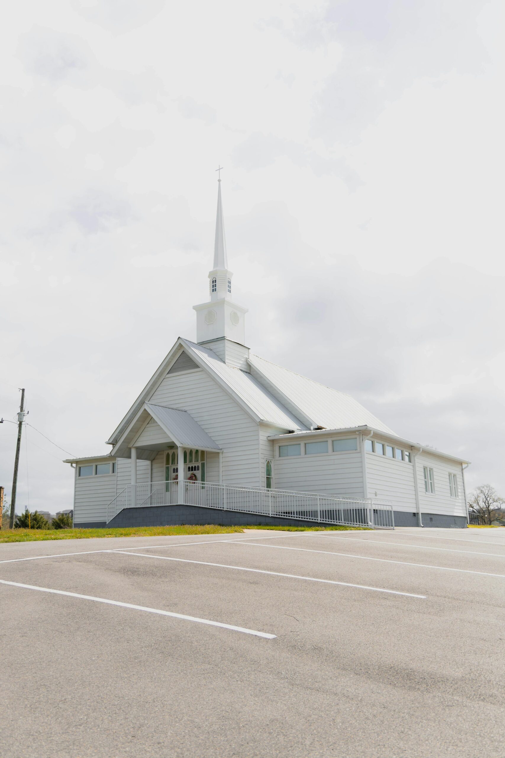 White church with steeple surrounded by trees